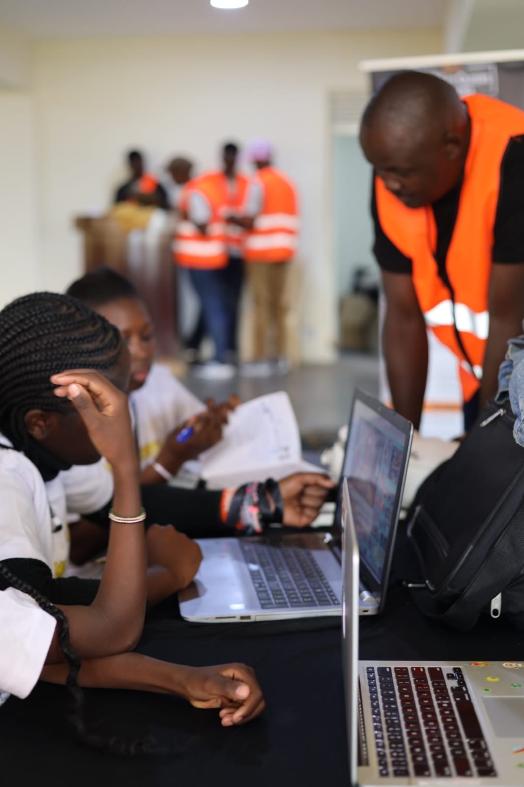 Young MRC Kenya participants collaborating around laptops