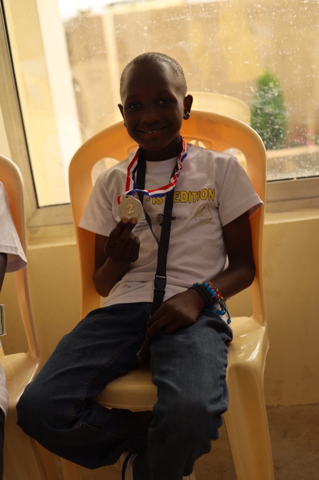 Young robotics competitor celebrating with an MRC Kenya medal